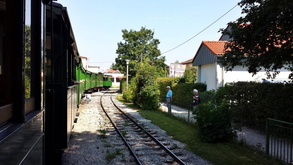 Departure of the green Chiemsee-Bahn train