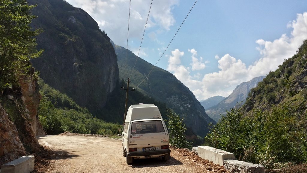 VW Bus Bulli auf Schotterstraße in Albanien im Kelmend