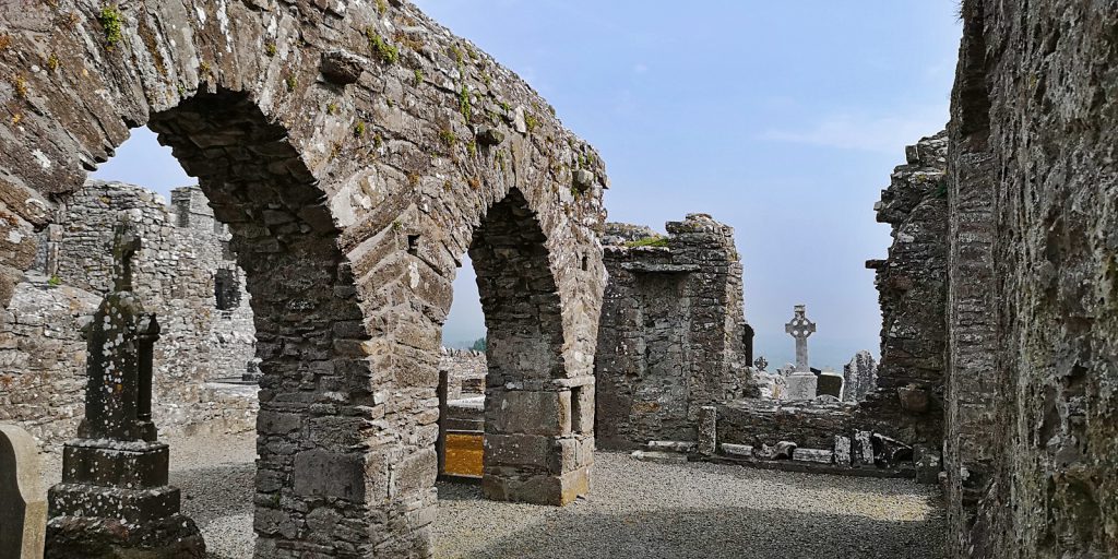 Ruinen auf dem Hill of Slane mit Keltenreuz im Hintergrund